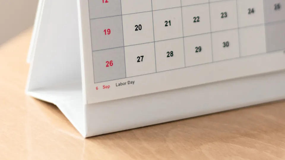 A desk calendar standing on a wooden table