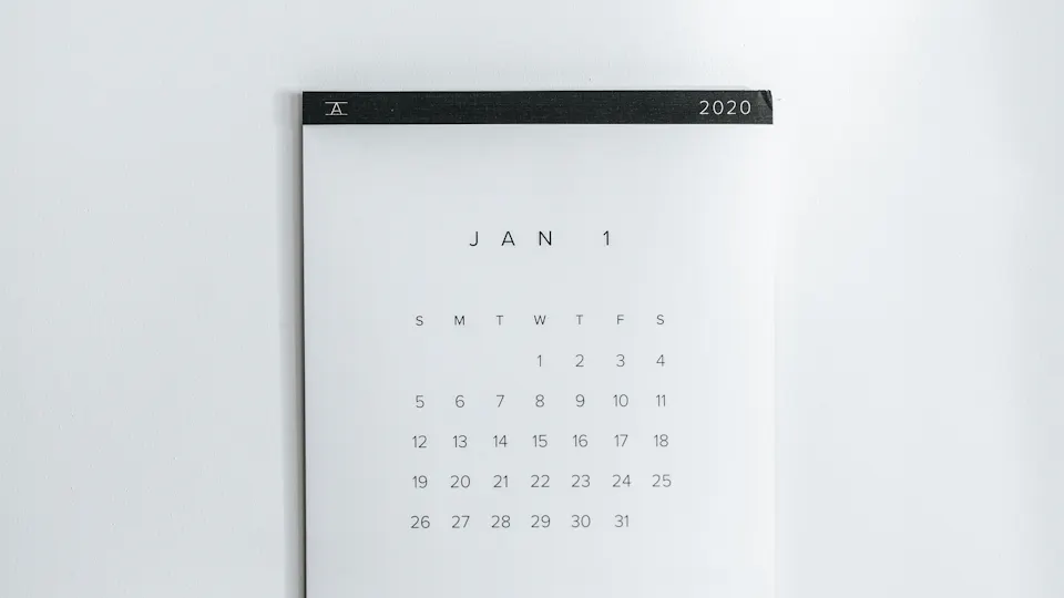 A white wall calendar page with a grid of days