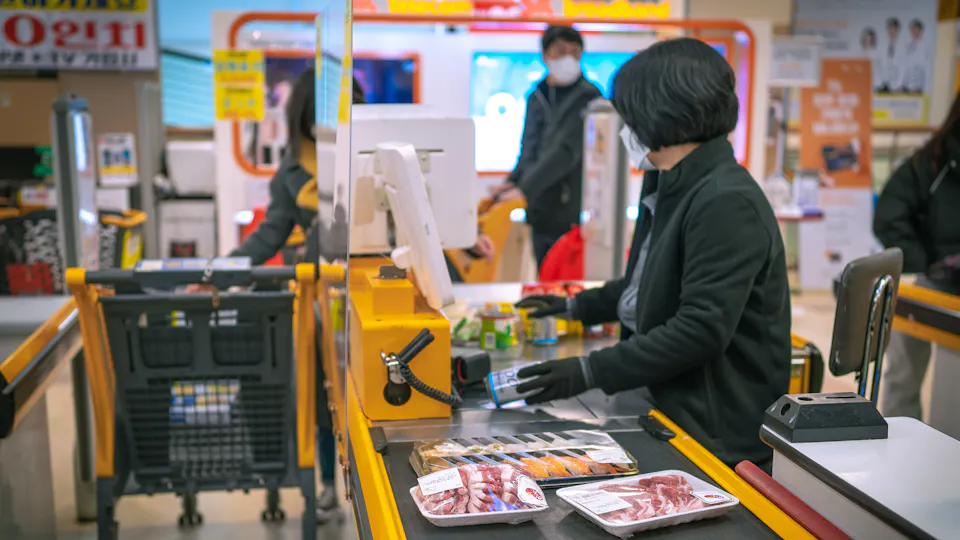 A cashier at a store checkout counter