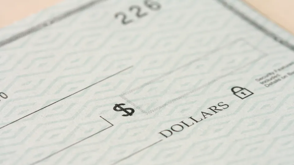 Close-up of a paper check showing the dollars line