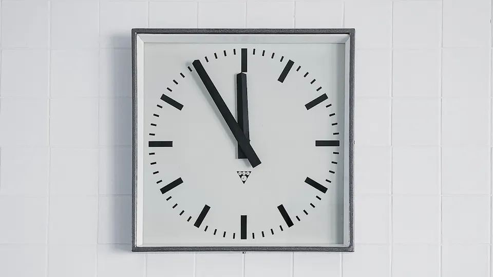 A plain white wall clock showing ten o'clock